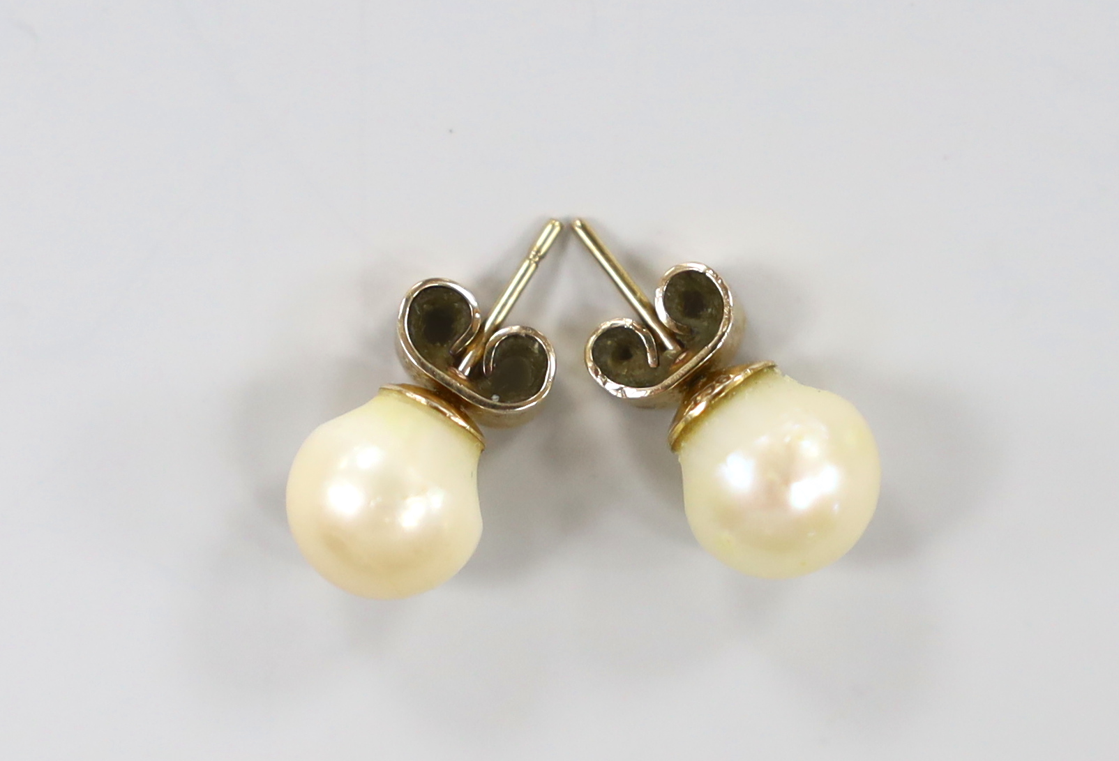 A pair of yellow metal and cultured pearl set ear studs, pearl diameter 9.2mm.